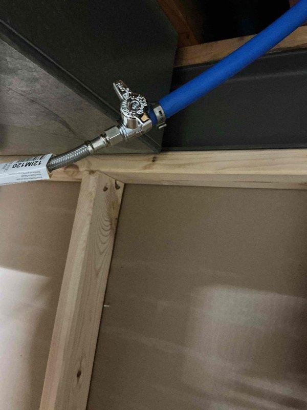 Successfully completed installation of a humidifier, connecting the water supply line to the existing plumbing system. Installed a quarter-turn shut-off valve with braided stainless steel supply line and secured proper connection of blue flexible feed line to the humidifier unit. All connections were tested and verified for proper operation with no leaks.
