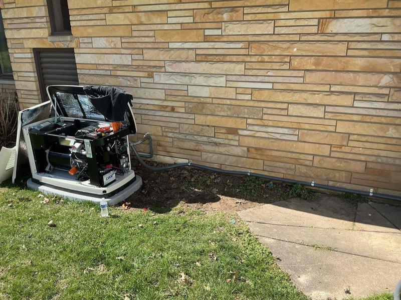 Installed 100-amp automatic transfer switch for generator system on exterior wall with stone facade. Mounted equipment on concrete pad adjacent to building, ran appropriate conduit along foundation, and connected necessary wiring to integrate with existing electrical service.