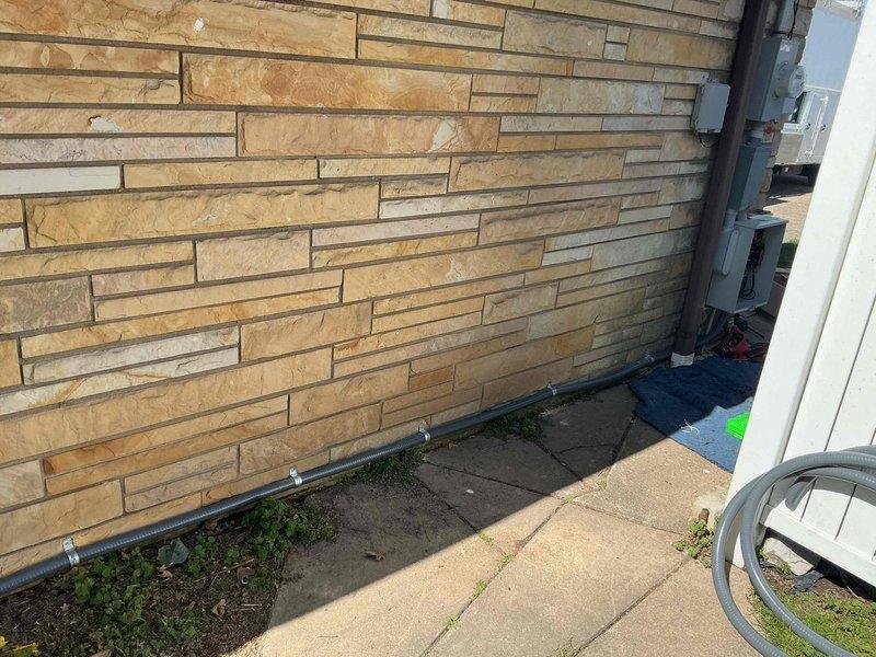 Installed 100-amp automatic transfer switch for generator system on exterior wall with stone facade. Mounted equipment on concrete pad adjacent to building, ran appropriate conduit along foundation, and connected necessary wiring to integrate with existing electrical service.