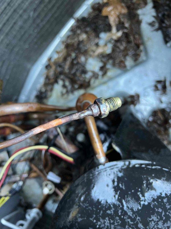 Completed warranty follow-up service to address refrigerant leak on suction line. System was pumped down and leak repair performed on the copper suction line where significant corrosion and crystalline buildup were present. Visual inspection revealed thermal damage to interior cabinet panel and extensive white crystalline deposits on copper tubing and surrounding components, indicating previous refrigerant leak. Repaired compromised suction line connection point, cleaned affected area, and verified system integrity. All electrical connections inspected and confirmed secure. System restored to operational status with zero balance due from customer.