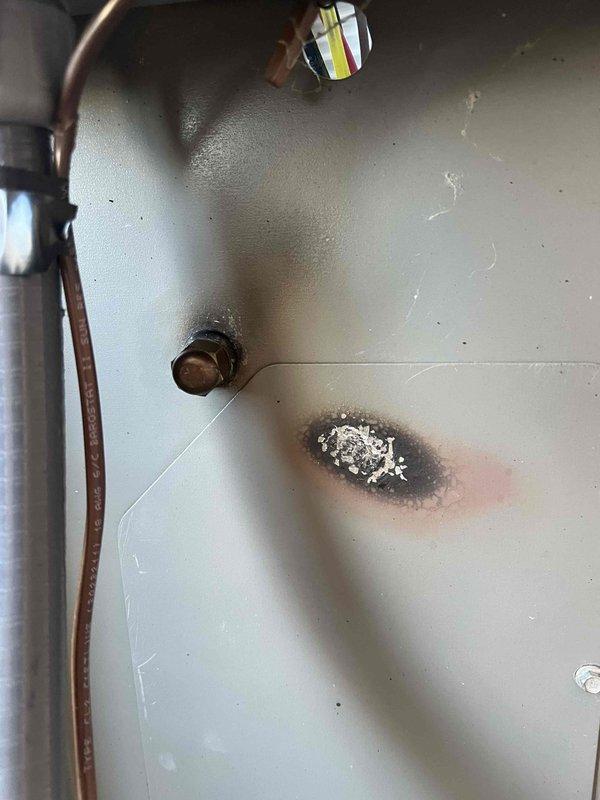 Completed warranty follow-up service to address refrigerant leak on suction line. System was pumped down and leak repair performed on the copper suction line where significant corrosion and crystalline buildup were present. Visual inspection revealed thermal damage to interior cabinet panel and extensive white crystalline deposits on copper tubing and surrounding components, indicating previous refrigerant leak. Repaired compromised suction line connection point, cleaned affected area, and verified system integrity. All electrical connections inspected and confirmed secure. System restored to operational status with zero balance due from customer.