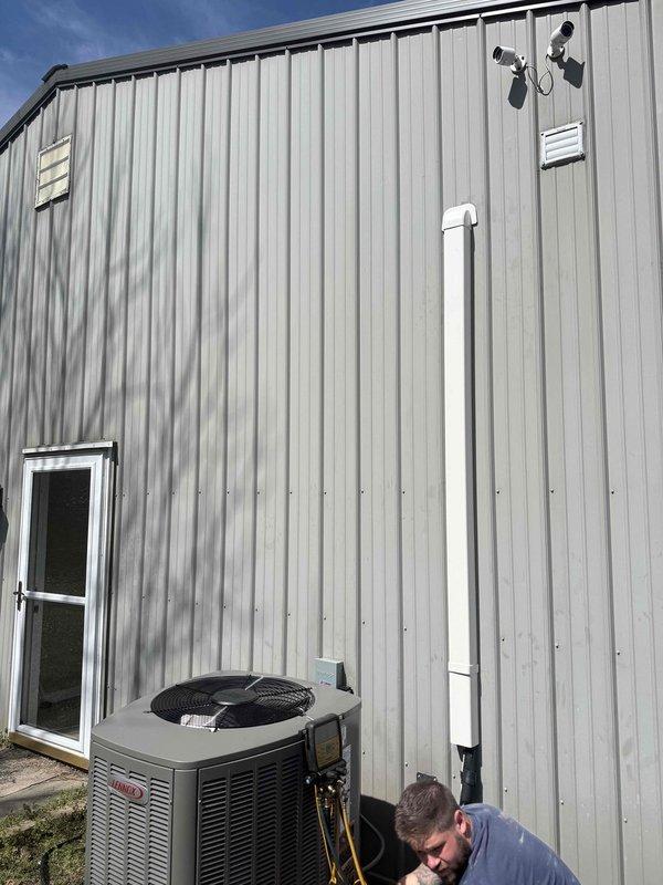 Completed installation of 3-ton, 19 SEER heat pump system including outdoor condensing unit and indoor air handler. Mounted air handler horizontally in attic space with proper clearances, installed new flexible ductwork throughout attic with secure fastening and connections, and positioned outdoor unit on ground-level pad against exterior metal building wall. Ran refrigerant lines, condensate drain piping, and electrical connections between indoor and outdoor equipment, ensuring all components were properly secured and operational per manufacturer specifications.