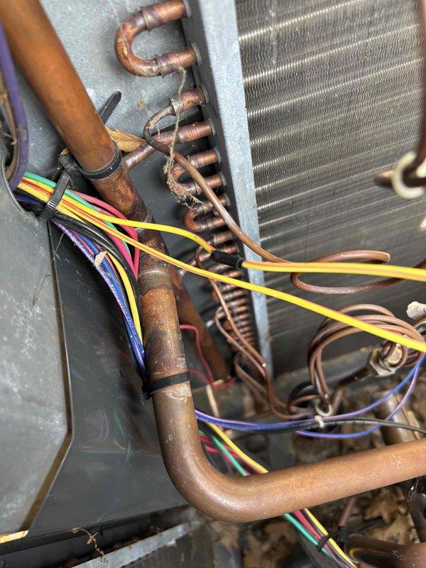 Responded to no heat call on 4-year-old system with no airflow or system operation. Performed diagnostic inspection and confirmed no power issues at breaker panel or disconnect. Inspected internal components including heat exchanger coil, refrigerant lines, and electrical connections. Observed copper refrigerant tubing with normal oxidation consistent with age and operation. Verified heat exchanger fins intact and coil assembly in serviceable condition. Traced wiring harness and control connections throughout unit. Documented system condition with photographs for service records.