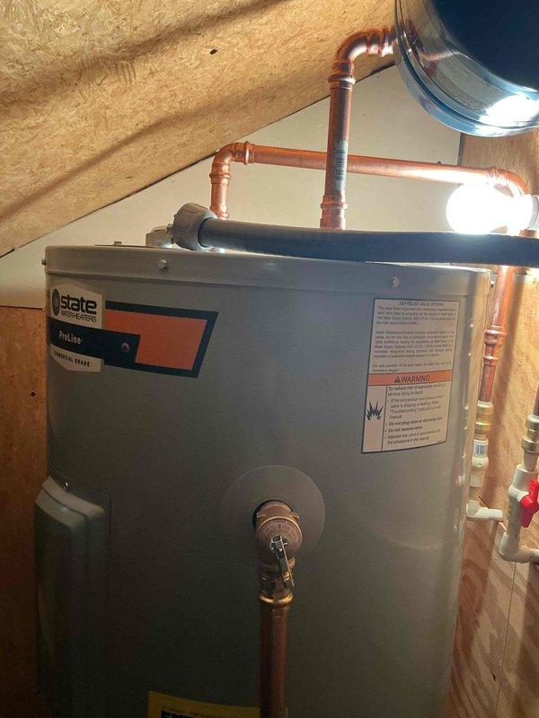 Successfully completed installation of a State Industries ProLine water heater in an attic space. The installation included proper venting with flue pipe connection, copper supply line connections with shut-off valves, and all necessary safety labeling in accordance with manufacturer specifications and local plumbing codes.