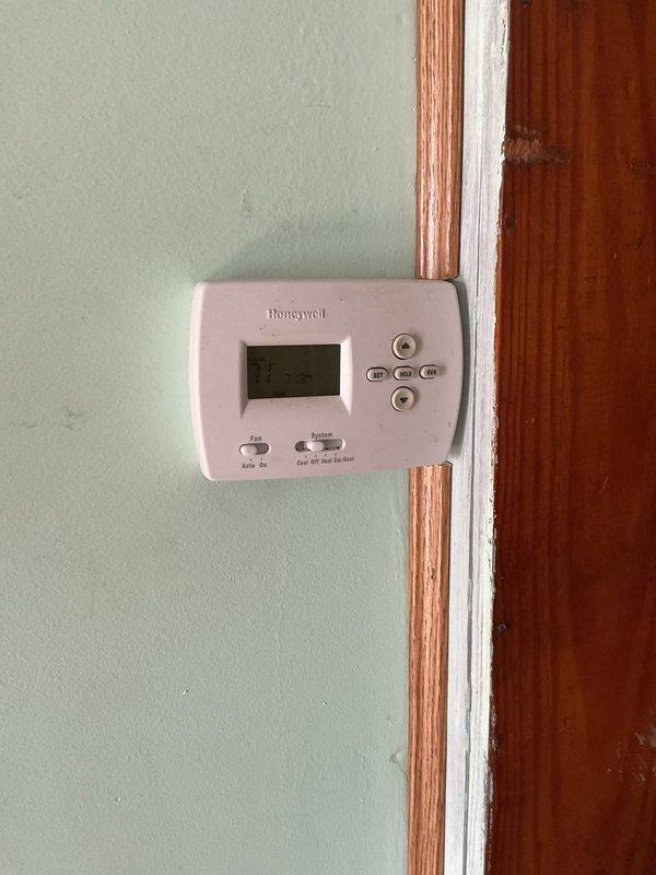 Responded to no heat call on 10-year-old heat pump system with airflow but no heating. Upon arrival, verified system was operating in emergency heat mode with thermostat set to 70°F and indoor temperature at 69°F. Performed diagnostic assessment of air handler unit and heat pump components, inspected Honeywell thermostat settings and confirmed proper mode selection. Evaluated refrigerant lines, condensate drainage system, and electrical connections at air handler. System found operating correctly on auxiliary heat strips with heat pump requiring further evaluation for heating capacity concerns.