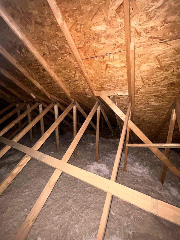 Conducted follow-up site visit to attic space for pending HVAC estimate. Documented existing conditions including exposed truss-style roof framing, OSB sheathing, and current blown-in insulation coverage between floor joists. Captured photographic evidence of attic access points, structural clearances, and insulation depth to finalize equipment placement recommendations and ductwork routing for proposed system installation.