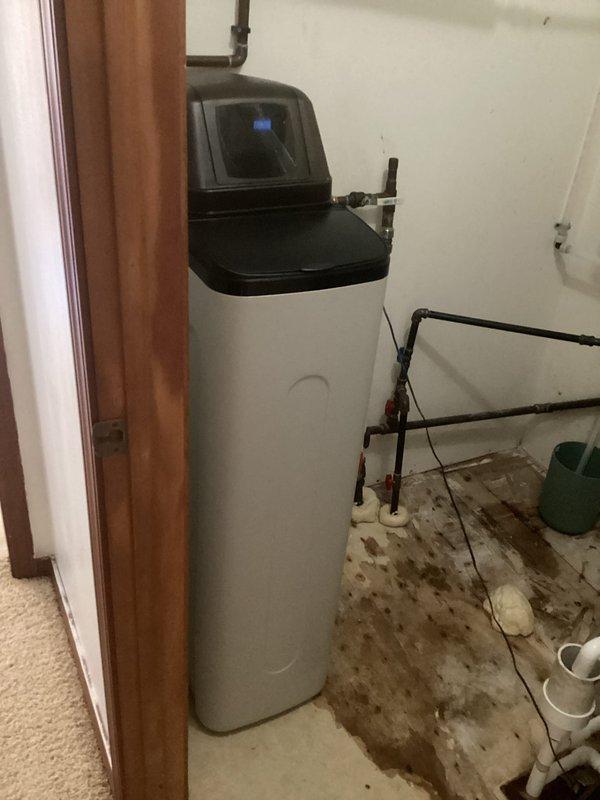 Installed new water softener system in utility room, including complete plumbing connections with copper and PVC piping, shutoff valves, and proper drainage lines. System was tested and verified operational with digital control head programmed for optimal water treatment performance.