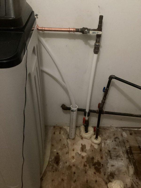 Installed new water softener system in utility room, including complete plumbing connections with copper and PVC piping, shutoff valves, and proper drainage lines. System was tested and verified operational with digital control head programmed for optimal water treatment performance.