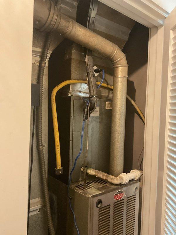Conducted comprehensive estimate for replacement of 22-year-old HVAC system in residential property with tight utility closet installation. Evaluated existing King brand vertical furnace unit with associated ductwork, gas line, and condensate drain configuration. Assessed outdoor condensing units positioned on gravel pads alongside brick exterior, including existing Trane equipment. 

Recommended 2.5-ton two-stage system to optimize cooling performance for main foyer and rear two bedrooms, which were identified as priority zones. Evaluated existing flexible and rigid ductwork routing, including tan flexible ducts and gray corrugated runs connecting to furnace cabinet. Documented gas line configuration, electrical connections, and PVC condensate drainage system for replacement planning. Photographed current equipment layout to develop installation strategy for confined closet space with multiple utility connections. Provided Green tier, A+ rated estimate addressing system capacity requi