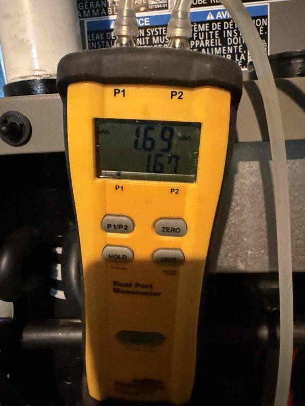 Completed installation of 2-ton, 18 SEER air conditioning system with 97% AFUE upflow furnace in basement location. System commissioning verified proper static pressures with manometer readings of 169 and 160, confirming optimal airflow through ductwork and equipment operation within manufacturer specifications.