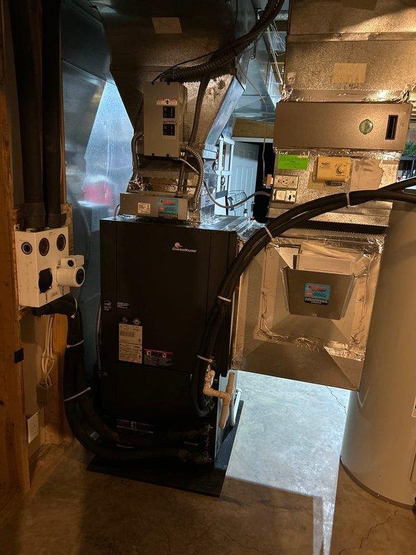 Completed follow-up visit to finalize HVAC installation in residential basement mechanical room. Verified proper installation and connection of Amana furnace unit with associated flexible ductwork system extending to ceiling and wall distribution points. Confirmed galvanized sheet metal ductwork network properly secured and connected to air handler unit with appropriate sealing at all joints and transitions. Documented completed installation showing furnace, air handler, water heater, and full ductwork system operational and ready for service.