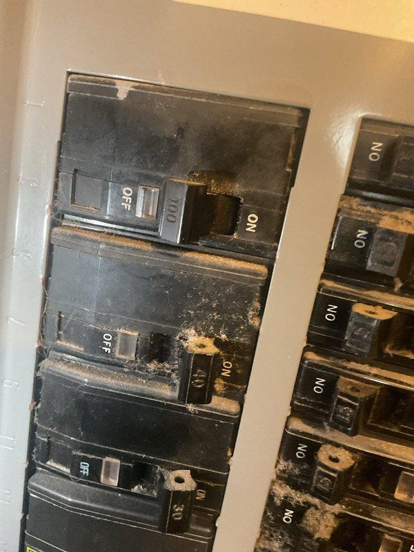 Conducted comprehensive HVAC replacement estimate for non-operational aging system. Documented existing thermostat wiring configuration showing heat pump setup with multiple wire connections to terminal block. Identified critical safety concern with main electrical panel exhibiting extensive burn marks, heat damage, and charred discoloration around multiple circuit breakers, indicating previous electrical overheating or arcing events. Provided homeowner with detailed replacement options and recommendations addressing both failed HVAC system and electrical panel safety hazards requiring immediate attention.