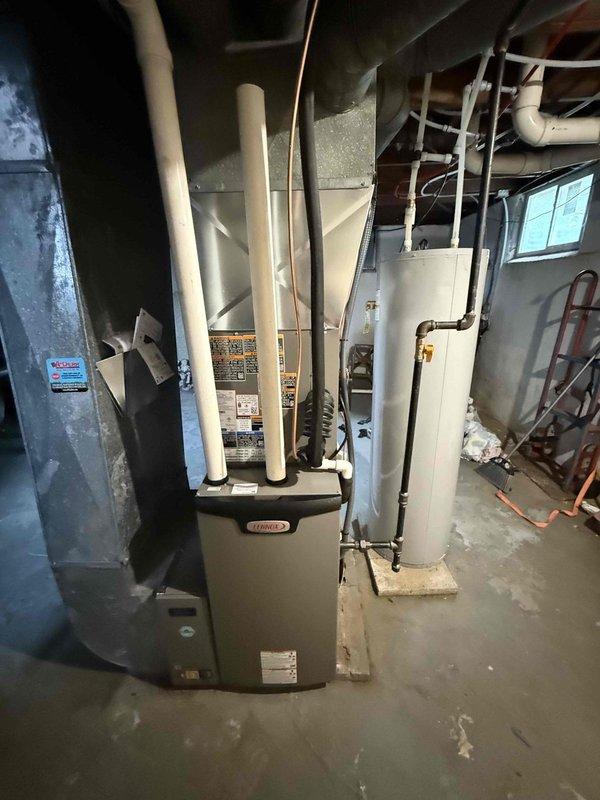 Completed installation of a 2-ton, 18 SEER Lennox cooling system with a 97% AFUE upflow furnace in the basement mechanical room. Installed outdoor condenser unit on concrete pad with proper electrical disconnect and refrigerant line connections, along with PVC intake and exhaust venting for high-efficiency furnace operation, ensuring all components meet manufacturer specifications and local code requirements.