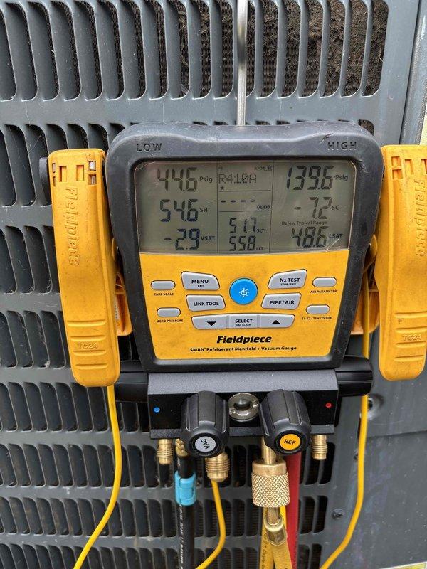 Responded to service callback for HVAC system failure following previous low voltage wire repair. Upon arrival, system remained non-operational despite prior technician's work. Performed comprehensive diagnostic assessment of unit including visual inspection of heat exchanger coils, refrigerant lines, and electrical components. Connected Fieldpiece SMAN manifold gauges to measure system pressures and temperatures, recording readings of 446 PSI low side and 1396 PSI high side with superheat at 546°F. Inspected copper refrigerant lines with foam insulation showing wear and discoloration. Examined condenser coil fins which displayed dust accumulation and typical outdoor equipment wear. Documented all findings with detailed photographs of internal components, pressure readings, and system conditions for accurate service records and potential warranty claims. System issue persists and requires further troubleshooting to identify root cause beyond initial low voltage wiring concern.