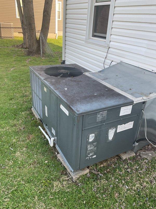 Conducted comprehensive HVAC replacement estimate for existing packaged heating and cooling system showing significant weathering and operational age. Evaluated outdoor unit positioned on concrete pad with proper electrical connections and refrigerant lines, documenting current system configuration including condenser and air handler components. Measured equipment spacing and assessed installation area accessibility, photographed existing system condition with visible dirt accumulation and surface deterioration, and provided homeowner with detailed replacement options for upgraded high-efficiency HVAC system to improve comfort and energy performance.