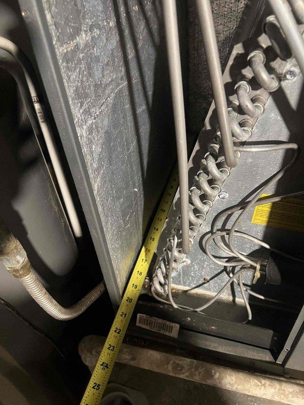 # HVAC Service Completed

Responded to service call for 9-year-old air conditioning system running but not cooling properly. Upon arrival, performed comprehensive diagnostic evaluation of the cooling system and indoor air handler unit.

Conducted visual inspection and measurements of internal components, including refrigerant lines, electrical connections, and junction box terminals. Opened furnace access panel to examine heat exchanger and internal ductwork configuration. Documented system measurements and component conditions with detailed photographs for service records.

Identified failed component affecting cooling performance and completed necessary replacement to restore proper system operation. Verified all electrical connections at terminal block were secure and properly fastened. Inspected condensate drain lines and PVC venting system for proper drainage and clearance.

System returned to normal cooling operation following repairs. Customer requested name of replaced part and