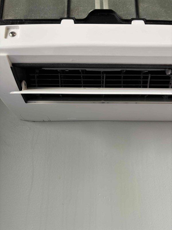 Performed diagnostic inspection on mini-split indoor unit located in basement closet. Opened front panel and accessed evaporator coil assembly to assess cleaning requirements. Identified need for AprilAire 35 humidifier pad replacement on associated system. Documented internal components including horizontal fin arrangement and air distribution louvers. Part has been ordered for follow-up installation, estimated completion time of 60 minutes upon arrival. System currently operational (green priority status). Captured photographic documentation of unit interior and coil condition for service records.