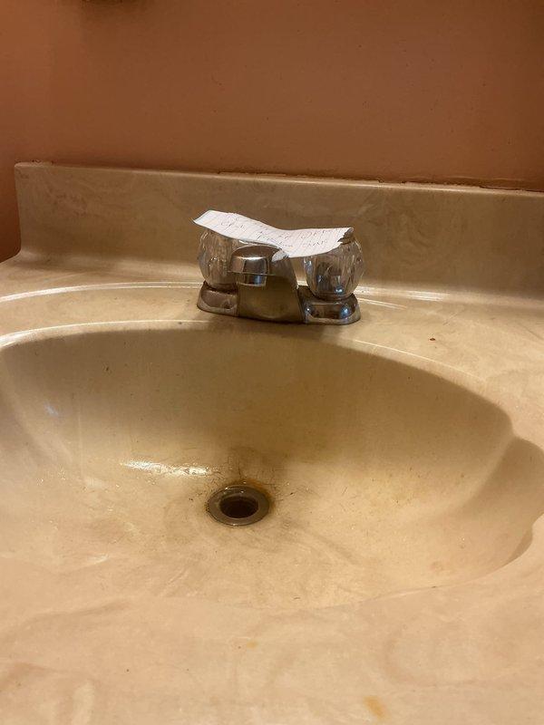 Responded to bathroom sink clog complaint and successfully cleared the drain obstruction. Upon inspection, found standard P-trap configuration with chrome two-handle faucet assembly; noted aging fixtures with visible corrosion on supply valves and general wear throughout plumbing components. Restored proper drainage function and completed service.