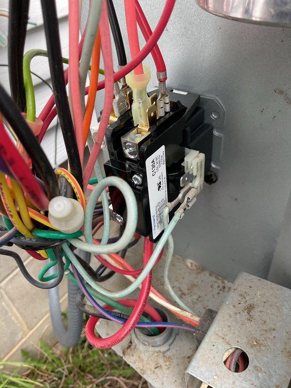 # HVAC Service Completed

Responded to service call for 5-year-old air conditioning system with inoperative fan and complete loss of heating and cooling capability. Upon arrival, performed visual inspection and diagnostic testing of outdoor condensing unit.

Identified failed contactor as primary issue preventing compressor and condenser fan operation. Contactor showed signs of electrical failure with burned or pitted contacts preventing proper circuit closure. Verified all wire connections at contactor terminals for proper seating and condition, noting multiple color-coded wires including line voltage and control circuit wiring.

Utilized Fieldpiece SMAN digital manifold gauge set to assess system pressures and temperatures. Connected refrigerant hoses to service ports and recorded operating parameters. Display readings indicated abnormal pressure conditions consistent with non-operational compressor. Monitored both high-side and low-side pressures along with corresponding saturation 