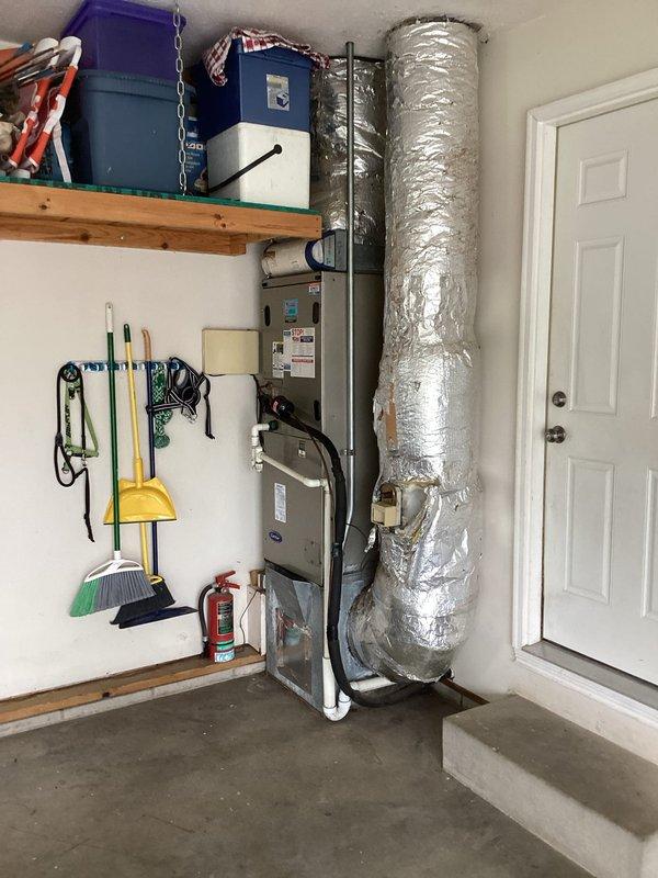 Completed comprehensive assessment of existing downflow HVAC system in residential garage utility area for replacement estimate. Documented current air handler unit configuration, ductwork routing, and spatial constraints including 9-foot 4-inch floor-to-ceiling clearance. Evaluated equipment accessibility, existing base condition, and prepared detailed specifications for Green A+ rated replacement system installation with proper sizing measurements for furnace, coil, and base components.