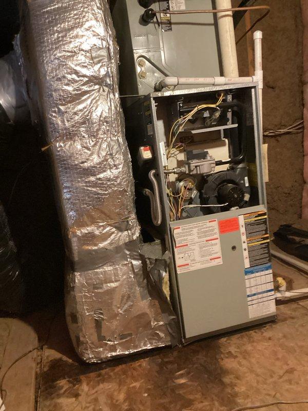 Responded to no cooling complaint on aging air conditioning system. Performed diagnostic inspection of HVAC equipment, accessing furnace unit to examine blower motor assembly, gas valve components, and electrical connections. Verified proper operation of indoor air handler components and documented system configuration including ductwork, condensate drainage lines, and ventilation infrastructure for service records.