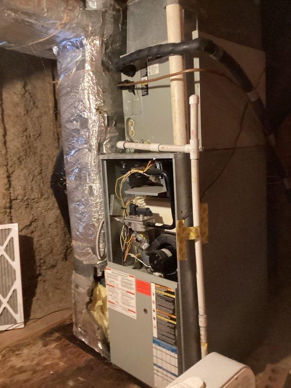 Responded to no cooling complaint on aging air conditioning system. Performed diagnostic inspection of HVAC equipment, accessing furnace unit to examine blower motor assembly, gas valve components, and electrical connections. Verified proper operation of indoor air handler components and documented system configuration including ductwork, condensate drainage lines, and ventilation infrastructure for service records.