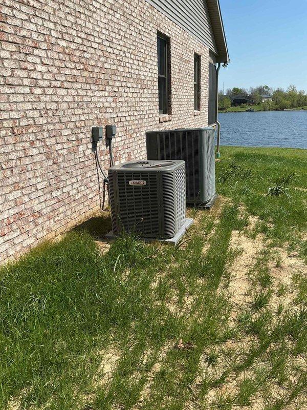 Responded to customer concern regarding unlevel outdoor condensing units affecting system performance. Upon arrival, inspected two HVAC condensing units installed side by side on shared concrete pad at exterior brick wall. Visual assessment confirmed units were not properly leveled on pad, which can lead to compressor strain, refrigerant migration issues, and premature equipment failure. Verified electrical disconnects and conduit connections were secure between wall-mounted junction boxes and both units. Documented current installation conditions with photographs showing unit positioning, concrete pad settlement, and surrounding grade conditions for service records.