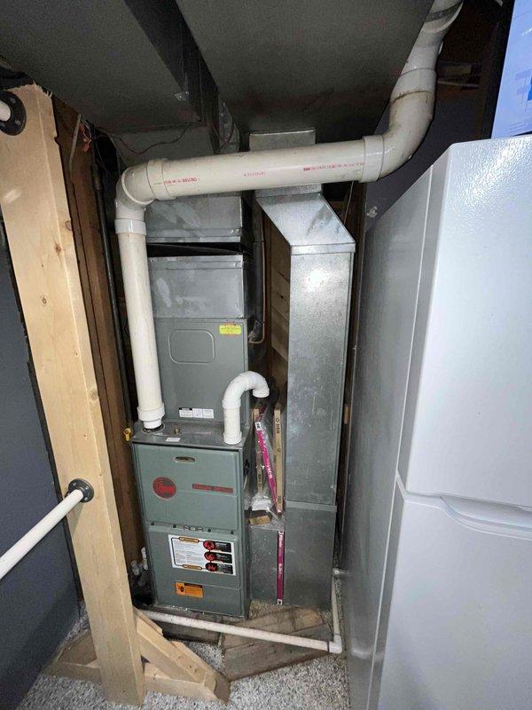 Completed replacement estimate for 30-year-old non-functional HVAC system. Assessed existing gray furnace unit with associated PVC venting and drainage lines in basement mechanical room, along with exterior condensing unit showing significant rust staining on access panel compartment. Customer requested replacement-only estimate with no repair options due to age and condition of equipment.