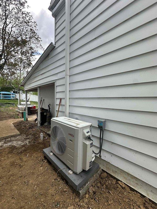Completed reinstallation of mini split system at residential property. Outdoor condenser unit properly mounted on concrete pad with electrical disconnect and refrigerant lines connected through exterior wall. System tested and verified operational upon completion.