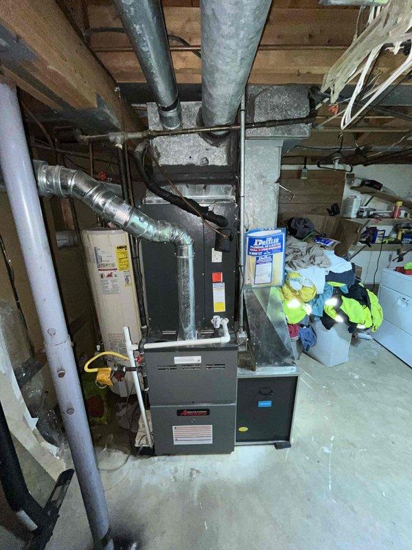 Conducted comprehensive replacement estimate for non-functional HVAC system in basement utility area. Evaluated existing dark gray furnace unit with connected galvanized and flexible ductwork, assessed plenum transitions, and documented current system configuration including proximity to water heater and existing infrastructure. Provided homeowner with complete replacement options during consultation, captured detailed photographic documentation of equipment layout, ductwork routing, and mechanical room conditions to develop accurate system replacement proposal.