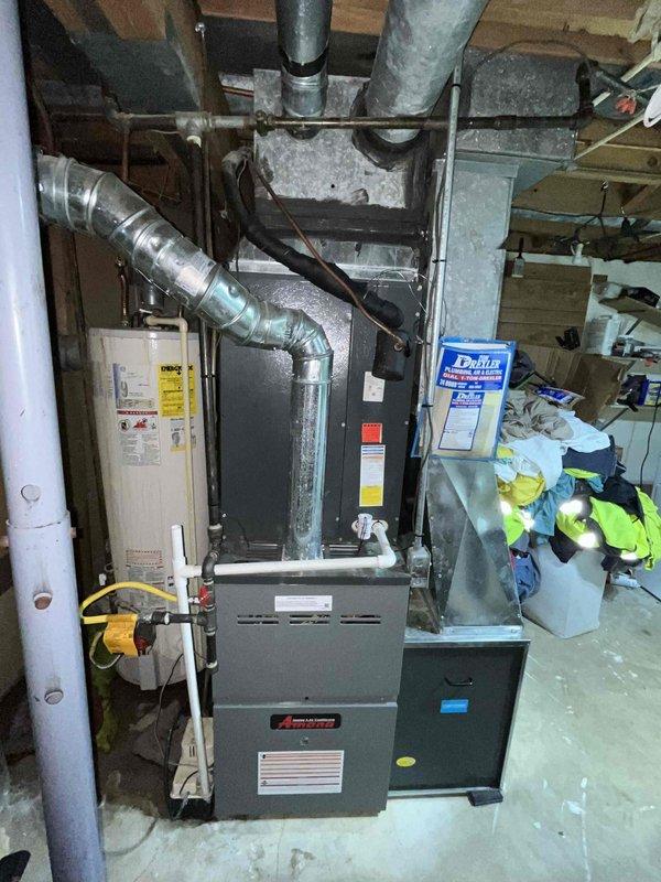 Conducted comprehensive replacement estimate for non-functional HVAC system in basement utility area. Evaluated existing dark gray furnace unit with connected galvanized and flexible ductwork, assessed plenum transitions, and documented current system configuration including proximity to water heater and existing infrastructure. Provided homeowner with complete replacement options during consultation, captured detailed photographic documentation of equipment layout, ductwork routing, and mechanical room conditions to develop accurate system replacement proposal.