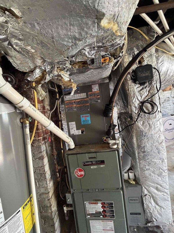 Completed installation of a 4-ton, 15.5 SEER upflow air conditioning system with zoning capabilities. The new AC unit was integrated with the existing Rheem Classic 90 Plus furnace in the basement mechanical space, with proper refrigerant line connections, electrical wiring, condensate drainage via PVC piping, and insulated ductwork configuration to support the multi-zone climate control system.