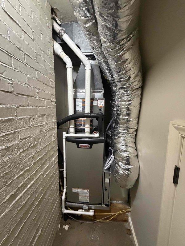 # HVAC Complete System Installation

Successfully completed installation of a 2-ton, 18 SEER high-efficiency split system for the upstairs zone. The system features a 99% AFUE upflow gas furnace positioned in a narrow utility closet with white brick walls. Installation included proper placement of the furnace unit with manufacturer specifications verified, white PVC condensate drain and vent piping routed vertically from the unit, and silver flexible supply ductwork configured to fit the confined space. Black flexible return ducting was connected to the upper portion of the furnace to complete the air distribution system.

Upon completion of the mechanical installation, performed comprehensive system startup and diagnostic testing using digital manifold gauges. Verified refrigerant charge, operating pressures, and temperature differentials across the evaporator coil to ensure optimal system performance. All readings confirmed proper system operation within manufacturer specifications. 
