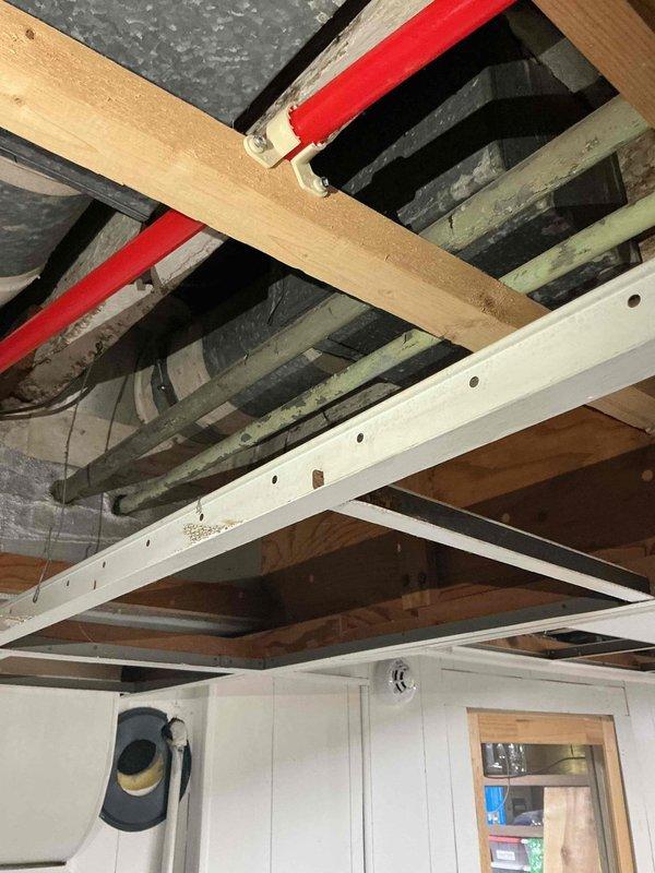 Conducted comprehensive whole home repiping estimate assessment. Evaluated existing plumbing infrastructure including exposed basement ceiling joists revealing original and reinforced framing with visible supply lines, and inspected bathroom fixtures including chrome dual shower head system with handheld attachment and wall-mounted controls. Documented current plumbing conditions through detailed photography to provide accurate scope of work for complete residential repiping project.