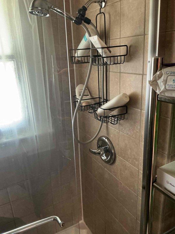 Conducted comprehensive whole home repiping estimate assessment. Evaluated existing plumbing infrastructure including exposed basement ceiling joists revealing original and reinforced framing with visible supply lines, and inspected bathroom fixtures including chrome dual shower head system with handheld attachment and wall-mounted controls. Documented current plumbing conditions through detailed photography to provide accurate scope of work for complete residential repiping project.