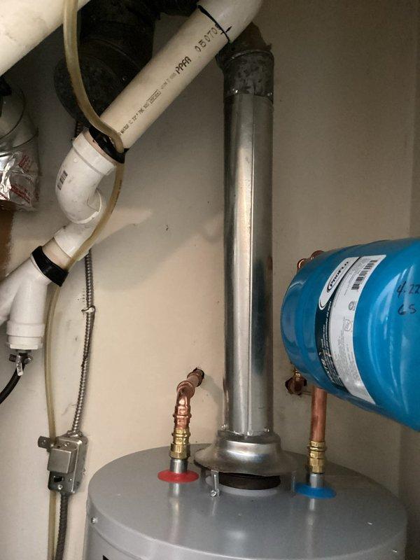 Installed a 40-gallon gas tall water heater (57 1/2" height x 21" width) in residential utility closet with proper venting through metallic exhaust flue. Connected hot and cold water supply lines using copper piping with brass fittings and shutoff valves, installed blue expansion tank on wall with appropriate piping connections, and ensured all plumbing connections met code requirements. Unit includes 6-year parts and 1-year labor warranty.