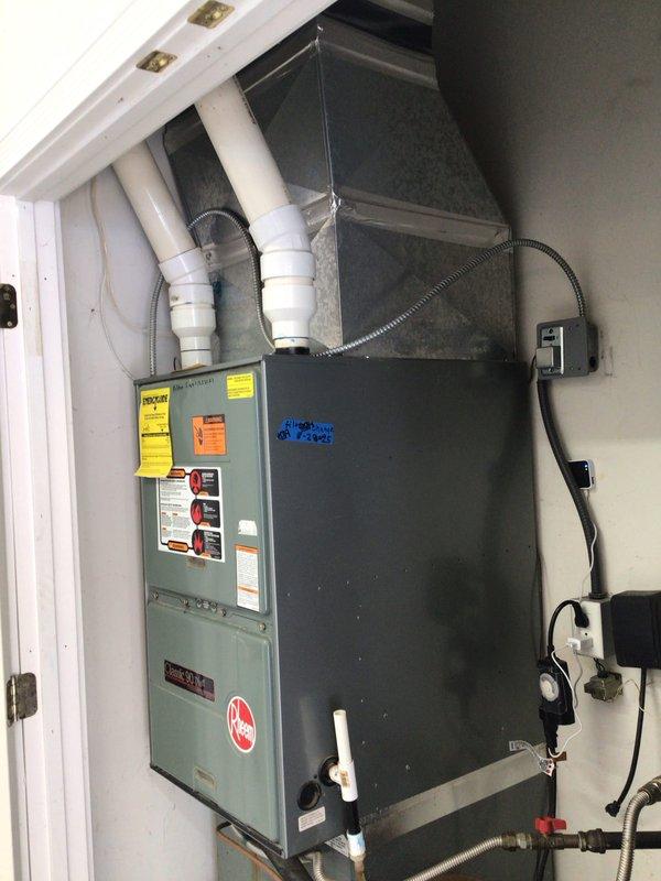 Completed dismissed visit on single-system residential HVAC installation. Performed visual inspection of Rheem furnace unit located in interior mechanical closet and outdoor air conditioning condenser positioned on exterior concrete pad. Verified proper installation of white PVC venting system, electrical connections via flexible conduit to wall-mounted disconnect, and gas line connections at furnace base. Inspected outdoor condenser unit including fan grille, horizontal louvers, electrical disconnect box, and PVC conduit routing along brick exterior wall. Documented equipment conditions and installation components through photographic records. All visible system components appeared properly installed with no immediate service concerns noted during dismissed visit inspection.