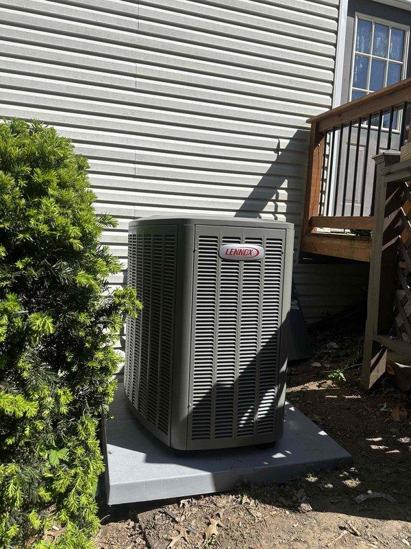 Completed installation of 3-ton, 19 SEER Lennox heat pump system with matching air handler at residential property. Unit positioned on concrete pad against exterior wall with proper clearances maintained, electrical disconnect mounted on siding with conduit run to condensing unit, and refrigerant lines routed and insulated per manufacturer specifications. System tested and operational upon completion.