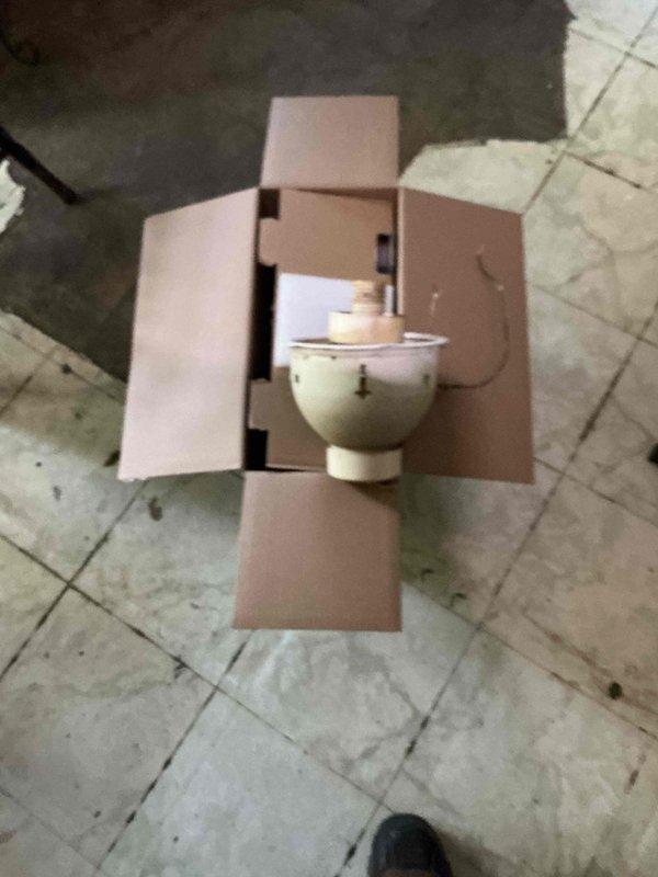 Responded to follow-up service call to complete lighting installation work previously scheduled. Upon arrival, confirmed that customer-supplied light fixtures were damaged and could not be installed. Documented existing ceiling-mounted decorative cage fixture currently in place and photographed uninstalled motor housing component still in packaging. Unable to complete installation due to defective customer-provided materials.