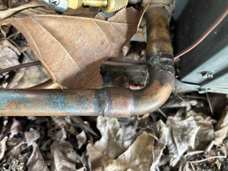 Completed follow-up repair on leaking refrigerant line joint on 10-year-old residential air conditioning system. Repaired corroded copper pipe connection that showed significant oxidation and patina formation on outdoor condensing unit. System restored to proper operation with adequate airflow confirmed at supply registers and refrigerant circuit integrity verified.