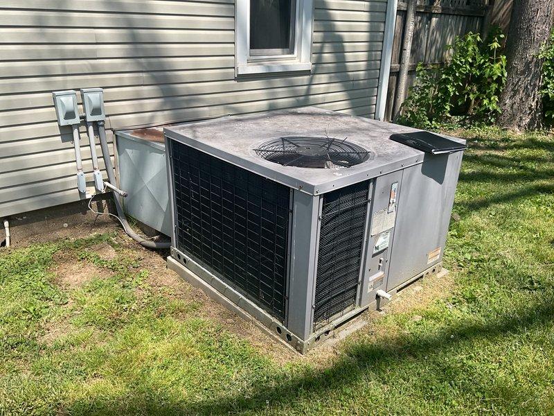 Conducted on-site assessment of residential cooling system damaged by fallen tree limbs. Evaluated packaged HVAC unit and associated ductwork/plenum for structural damage, operational integrity, and replacement requirements. Documented equipment condition showing weathering, surface oxidation, and impact damage to exterior components. Provided comprehensive replacement quote for complete system installation on existing concrete pad with necessary electrical and refrigerant line connections.