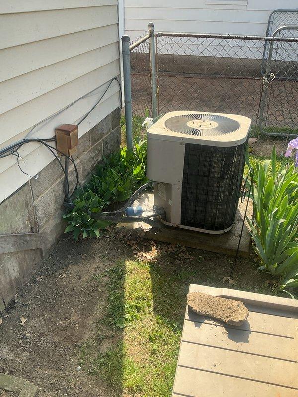 Responded to no-cool complaint on Goodman HVAC system with indoor temperature reading 77°F against 73°F setpoint. Inspected vertical furnace installation in utility closet and outdoor condenser unit positioned in side yard. System was running but failing to achieve adequate cooling capacity. Evaluated ductwork connections and found concerns regarding potential air loss through crawl space as reported. Documented equipment condition showing 10+ year old unit with standard wear patterns typical for age of system.