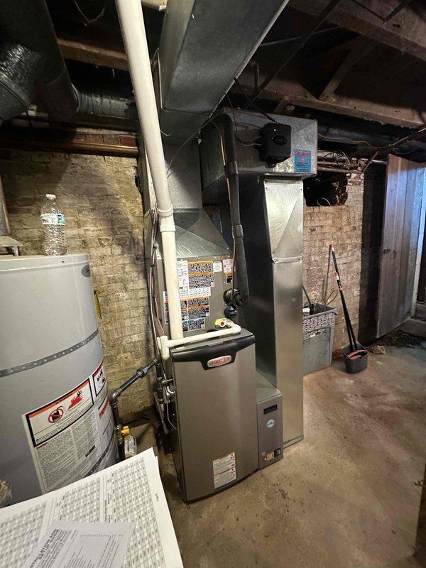 # HVAC Complete System Installation

Successfully completed installation of a 1.5-ton, 14.7 SEER air conditioning system paired with a 97% AFUE upflow gas furnace in basement mechanical room. Removed existing equipment and installed new high-efficiency furnace unit with properly sized ductwork and plenum connections. Configured upflow orientation to accommodate basement installation with supply ductwork extending to upper levels through existing ceiling joists.

Installed and connected new condensing unit for cooling system, ensuring proper refrigerant line routing and electrical connections. Integrated system controls and thermostat wiring for seamless operation between heating and cooling modes. Verified all ductwork connections were properly sealed and secured to metal plenum, ensuring efficient airflow distribution throughout the residence.

Positioned equipment to maintain adequate clearance from existing water heater and utility infrastructure in the confined basement space. Rout