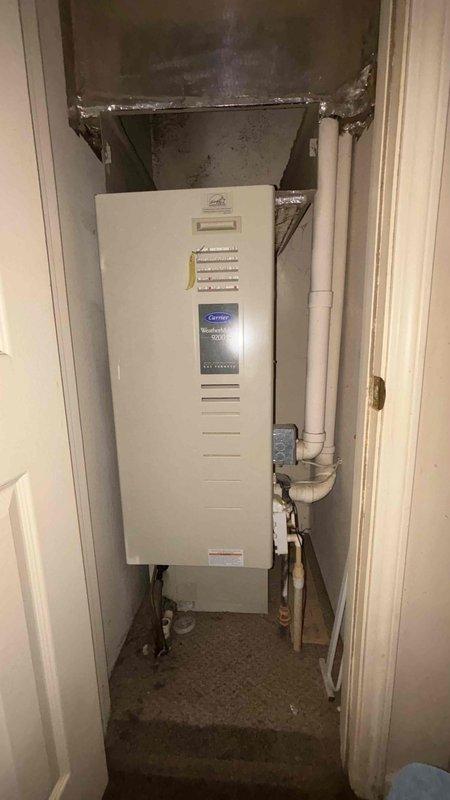 Conducted comprehensive HVAC replacement estimate for residential property. Evaluated existing outdoor air conditioning condenser unit showing signs of age and weathering, with discoloration on exterior surfaces. Assessed indoor tankless Carrier water heater installation in utility closet with digital control panel and proper copper piping connections. Documented current system configuration including electrical connections, condensate drainage, and equipment placement. Provided detailed replacement options and discussed available financing programs and payment plan structures to accommodate budget requirements.