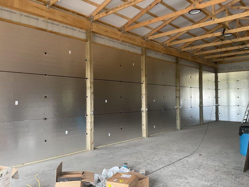 Completed HVAC estimate for new system installation in detached garage pole barn structure with no existing equipment. Assessed metal building with exposed wooden framing, cement board walls, and concrete slab flooring currently under construction. Evaluated space requirements, load calculations, and equipment placement options for climate control system to serve the workshop area.