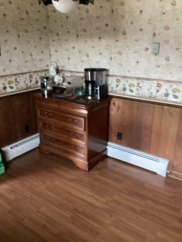 Performed comprehensive maintenance inspection on approximately 5-year-old boiler heating system. Evaluated overall system operation and identified components requiring replacement, including bell housing and backflow preventer. Inspected internal mechanical components, copper piping connections, and electrical wiring throughout the unit. Assessed radiator for removal as requested. System currently operational at time of service. Documented equipment condition with photographic evidence showing baseboard heating distribution system and internal boiler components with existing maintenance tags and connection points.