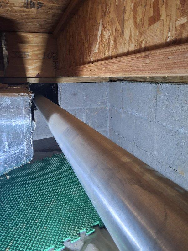Responded to service call for water intrusion affecting ductwork in crawlspace area. Upon inspection, discovered moisture infiltrating through dryer vent connection and entering the HVAC ductwork system located in below-grade crawlspace with concrete block foundation walls. Documented conditions with photographs showing affected areas including exposed ductwork, structural framing, and protective floor covering. Identified source of water entry and assessed extent of moisture penetration into the ventilation system to determine appropriate remediation recommendations.