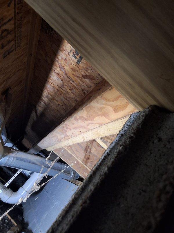 Responded to service call for water intrusion affecting ductwork in crawlspace area. Upon inspection, discovered moisture infiltrating through dryer vent connection and entering the HVAC ductwork system located in below-grade crawlspace with concrete block foundation walls. Documented conditions with photographs showing affected areas including exposed ductwork, structural framing, and protective floor covering. Identified source of water entry and assessed extent of moisture penetration into the ventilation system to determine appropriate remediation recommendations.