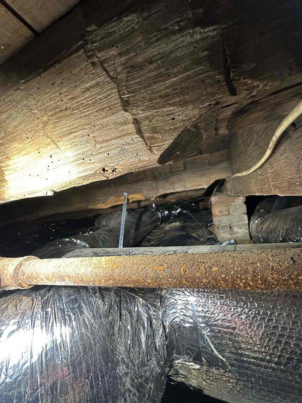 Completed full ductwork installation in crawl space area beneath residential structure. Installed insulated flexible ductwork throughout the underfloor space, properly secured with strapping to wooden floor joists to ensure stable positioning and prevent sagging. Routed ductwork to optimize airflow distribution while navigating existing electrical wiring and structural support elements. All ductwork wrapped with reflective silver insulation material to maximize energy efficiency and prevent condensation issues in the unconditioned crawl space environment. Installation completed in accordance with HVAC industry standards for residential duct systems.