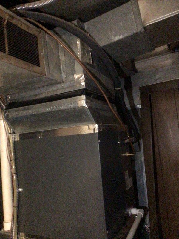 Responded to no cooling complaint where indoor blower fan operated but system failed to produce cold air. Upon inspection of air handler unit located in attic space, performed diagnostic evaluation of HVAC system. Verified airflow through supply vents and confirmed absence of evaporator coil freeze-up. Assessed electrical connections, refrigerant lines, and condensate drainage system for proper operation. Documented existing installation showing air handler with associated ductwork and plumbing infrastructure in serviceable condition.